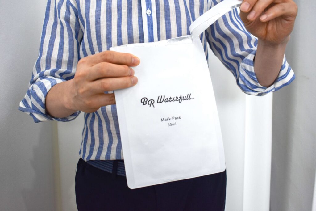 A man opens a face mask to apply it on his face