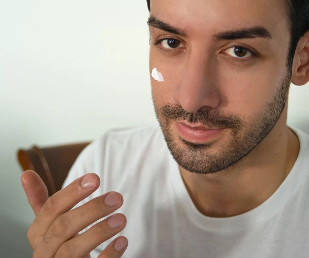 A man applying cream on his face