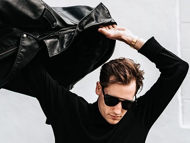 A man wearingsun glasses and a leather jacket